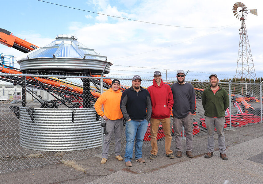 men in front of farm equipment